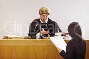 Present your case.... Serious young judge sitting in the courtroom with a stern facial expression.