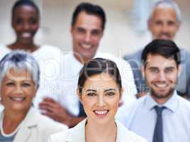 I lead by example. Portrait of a smiling businesswoman surrounded by a group of her colleagues.