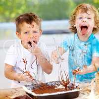 Kids will be kids. Shot of two messy little boys trying to make a cake.