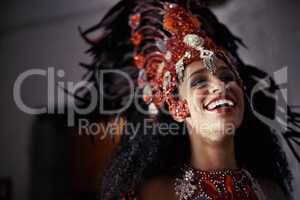 Performing live brings a smile to all. Cropped shot of a beautiful samba dancer wearing a headdress.