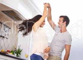 He brings out my playful side. A young couple playfully dancing in the kitchen.
