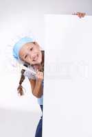 I love cooking.. Young girl wearing a chefs hat and holding a blank board reserved for copyspace.
