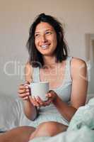 I cant wait to see what this day will bring. Shot of a young woman enjoying a relaxing cup of coffee in bed at home.