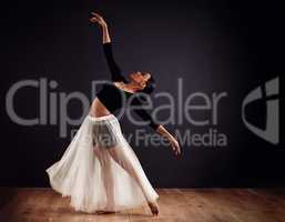 Elegance personified. Young female contemporary dancer using a soft white white skirt for dramatic effect.