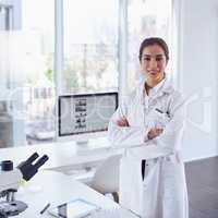 Advancing medical science. Portrait of a confident young female scientist standing with arms folded while looking at the camera in a laboratory.