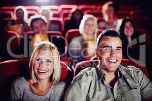 Enjoying a great comedy. A couple laughing and watching a movie together at the cinema.
