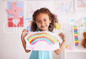 Dont you just love the colors. Shot of a little girl holding up a picture she painted of a rainbow.