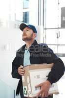 Hes on route to make a delivery. Shot of a handsome delivery man heading up a flight of stairs with a customers order.