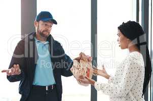 Im sorry but theres nothing I can do about this. Shot of a handsome delivery man negotiating with a dissatisfied female customer in the lobby.