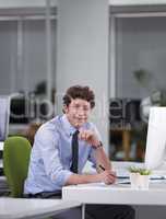 Hes a ver diligent worker. Cropped shot of a young businessman sitting at his desk.