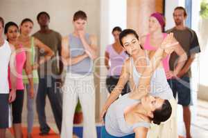 This is the correct technique. A yoga instructor demonstrating a routine with a client to the class.