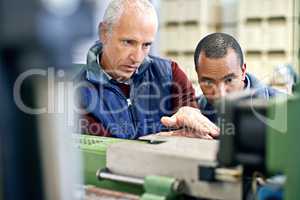 Were only as good as our equipment. Shot of two men working over factory machinery.
