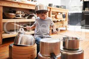 Rock star in the making. A young boy playing drums on pots and pans.