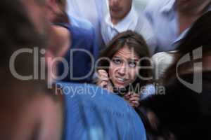 Drowning in people. Shot of a fearful young woman feeling trapped by the crowd.