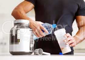 Getting enough protein in your diet. Cropped image of a bodybuilder making himself a protein shake.