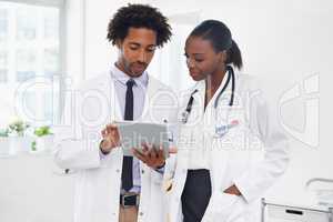 This is the correct diagnosis. Shot of two doctors standing in a room using a digital tablet.