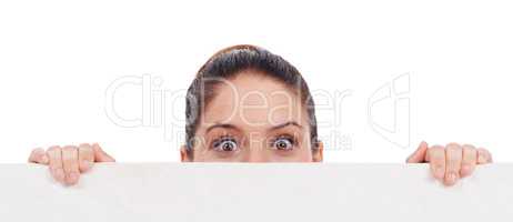 Can you believe this. Studio shot of a young women peering over a bank placard isolated on white.