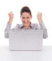 Finding fun online. Shot of a ecstatic-looking young woman seated in front of a laptop isolated on white.