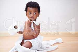 I swear the dog did it. Shot of a cute baby boy entangled in a roll of toilet paper.