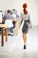 The trail of evidence..... A redheaded businesswoman walking back to her desk with toilet paper stuck in her skirt.