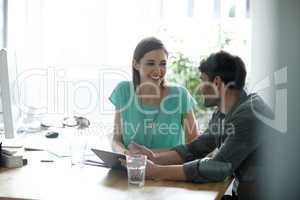 Time for some productive engagement. Shot of young professionals conversing positively together in an office.