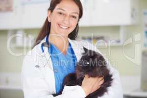 We take the best care of your pets. Portrait of a smiling female vet holding a dark feline.