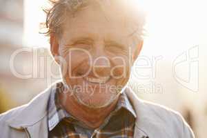 Hes got a sunny outlook on life. Portrait of a friendly-looking middle aged man outside.