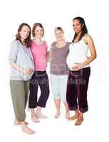 Bonded by the joy of impending motherhood. Pregnant friends standing together while isolated on white.