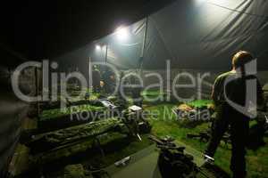 Turning in after a hard day of training. Soldiers getting ready to bunk down inside of their large tent.