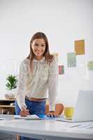 Ill write down a few tips on success for you. A young woman standing in her office with a pen and paper.