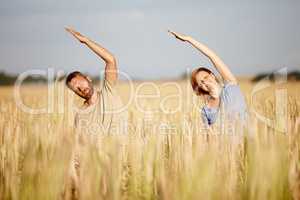 Souls in harmony. Shot of a serene couple enjoying a yoga workout in a crop field.