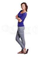 Standing with style. Full length side view of an attractive woman standing with her arms folded and smiling widely.