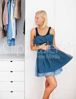 Ive found the perfect dress for the party. Beautiful young woman posing in a blue dress in front of a wardrobe mirror.