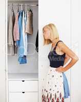 The perfect fit. Young woman holding a skirt in front of her while standing in front of her wardrobe.