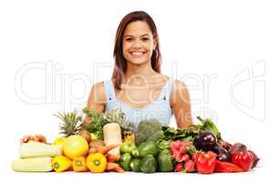 Feeling great about healthy choices. Smiling young woman alongside an assortment of healthy and fresh vegetables.