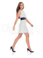 Walking with confidence. Studio shot of a stylishly-dressed young woman isolated on white.