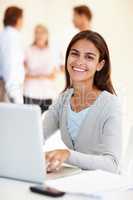 Shes positive its going to get done. Shot of an attractive young woman using a laptop in a brightly lit office.