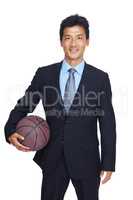 Captain of the team. An isolated portrait of a happy young businessman standing and holding a basketball.