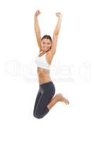Jumping for the joy of exercise. A young woman in sportswear jumping against a white background.