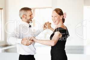 Still young at heart. Shot of a mature couple dancing together in formal attire.