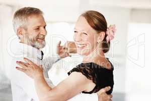 Keeping the romance alive. Shot of a mature couple dancing together in formal attire.