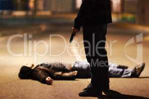Acts of violence. Man lying on the ground after being shot by a gun-wielding criminal.