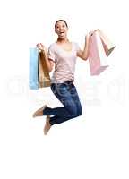 Pay day. Shot of an attractive young woman holding shopping bags and jumping in the air isolated on white.