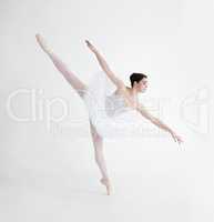 Balance is crucial. Elegant young ballerina dancing en pointe against a white background in penche position.