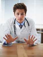 No need to worry at this point.... Shot of a young doctor gesturing not to worry to the camera.