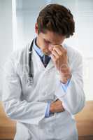 Feeling his patients anguish. Shot of an upset young doctor taking a moment to himself.