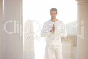 Starting the day in peace. Three quarter shot of a young man doing yoga outdoors.