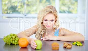 Temptation - Eat right and stay healthy. Pretty young woman being tempted to eat unhealthy food.