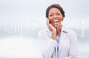 Laughter in the ocean breeze. A pretty african american woman having an enjoyable conversation while outdoors.