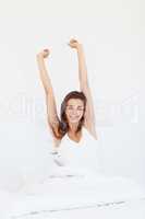 Feeling vitalized and refreshed. A smiling girl waking up and stretching her arms out.